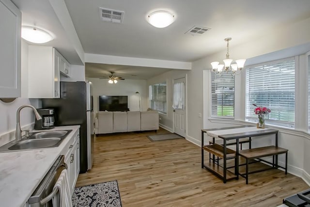 1414 Englewood Dr, Slidell, LA 70458 - kitchen with a sink, a chandelier, stainless steel appliances, white cabinets, and ceiling fan