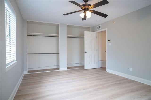 408 22 Nd St Unit 408, New Orleans, LA 70124 - unfurnished bedroom featuring light wood-type flooring, baseboards, two closets, and a ceiling fan