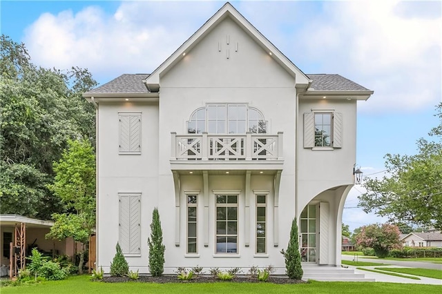 1001 Helios Ave, Metairie, LA 70005 - back of house with a balcony, stucco siding, a lawn, and a shingled roof