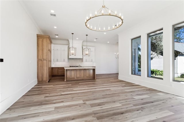 1001 Helios Ave, Metairie, LA 70005 - kitchen featuring a chandelier, open floor plan, tasteful backsplash, light wood-style floors, and recessed lighting