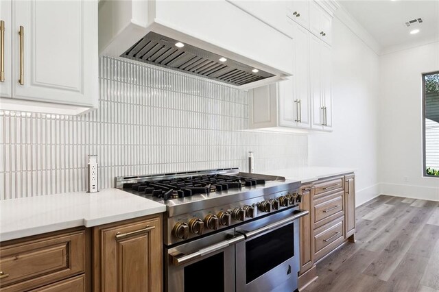 1001 Helios Ave, Metairie, LA 70005 - kitchen with double oven range, custom exhaust hood, decorative backsplash, white cabinets, and recessed lighting