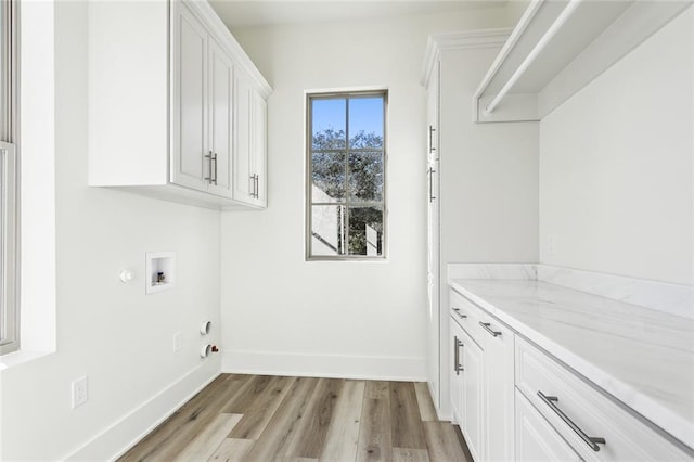 1001 Helios Ave, Metairie, LA 70005 - washroom featuring cabinet space, hookup for a gas dryer, light wood-style flooring, baseboards, and hookup for a washing machine