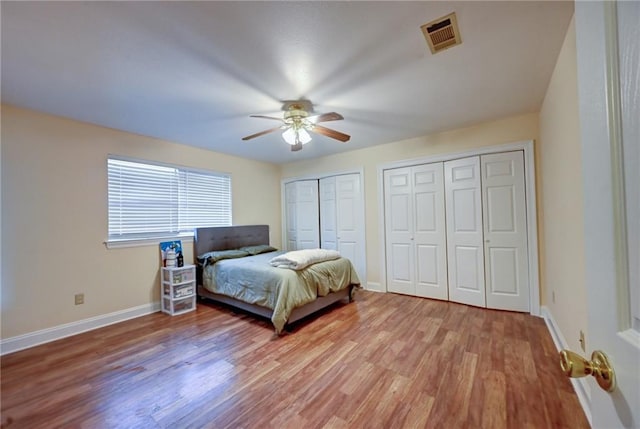 7701 Allison Rd, New Orleans, LA 70126 - bedroom with multiple closets, light wood-style flooring, baseboards, and a ceiling fan