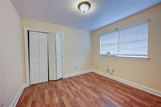 7701 Allison Rd, New Orleans, LA 70126 - unfurnished bedroom with light wood-style floors, baseboards, and a closet
