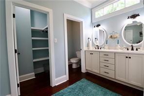 324 N Roman St, New Orleans, LA 70112 - bathroom with toilet, double vanity, wood finished floors, baseboards, and a walk in closet