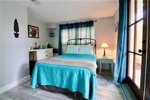 324 N Roman St, New Orleans, LA 70112 - bedroom featuring baseboards and wood finished floors