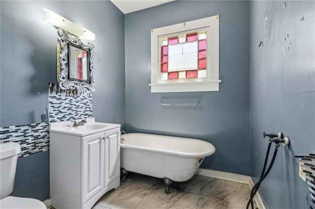 1432-1434 Ursulines Ave, New Orleans, LA 70116 - full bathroom with a freestanding tub, vanity, toilet, decorative backsplash, and marble finish flooring