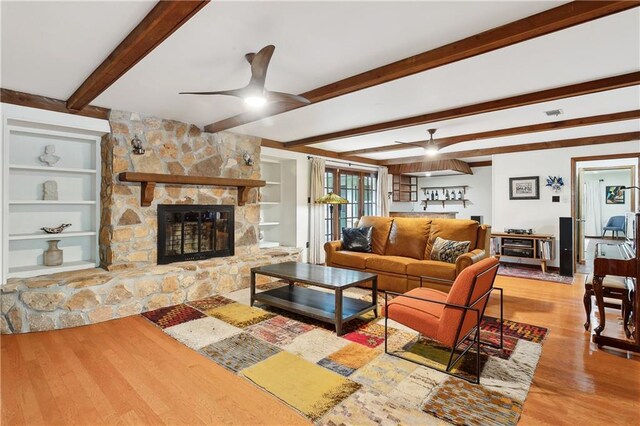 505 Hermitage Ct, Pearl River, LA 70452 - living room featuring wood finished floors, a ceiling fan, a stone fireplace, beamed ceiling, and built in features