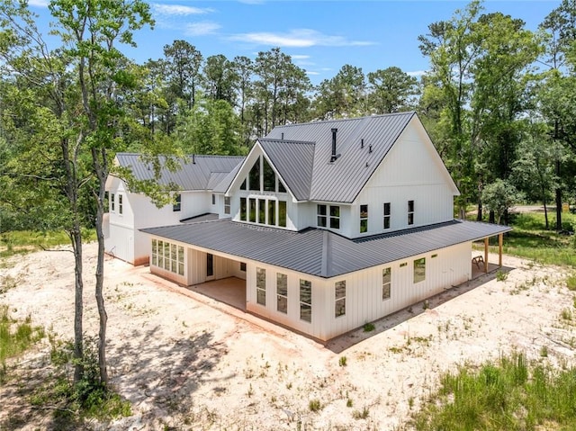 1190 Dove Park Rd, Covington, LA 70433 - rear view of property with dirt driveway, metal roof, and view of wooded area