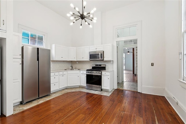 1314 Ursulines Ave, New Orleans, LA 70116 - kitchen featuring stainless steel appliances, a sink, a chandelier, light countertops, and wood-type flooring