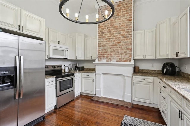 1238 Annunciation St, New Orleans, LA 70130 - kitchen with stainless steel appliances, light stone counters, dark wood finished floors, decorative light fixtures, and a chandelier