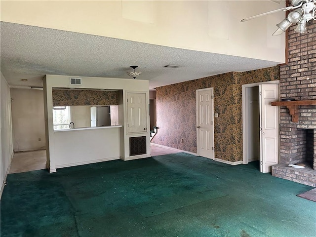41 Hollycrest Blvd Unit 41, Covington, LA 70434 - unfurnished living room with carpet, a brick fireplace, a textured ceiling, a ceiling fan, and baseboards
