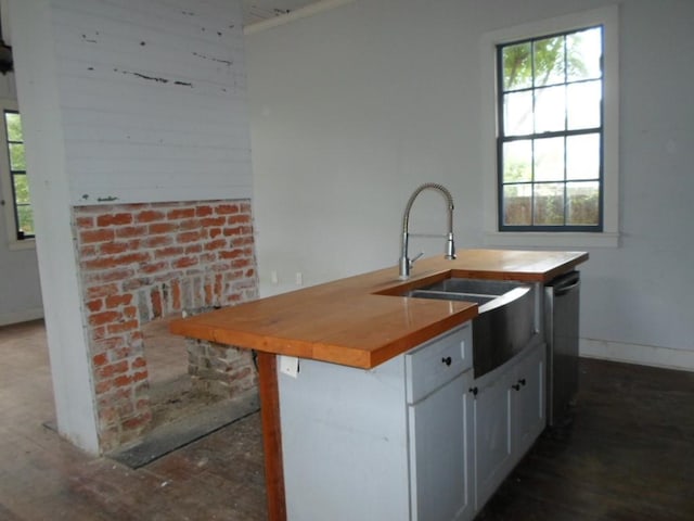 6315 Alhambra St, New Orleans, LA 70117 - kitchen featuring wooden counters, a sink, healthy amount of natural light, and baseboards