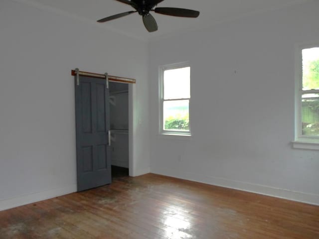 6315 Alhambra St, New Orleans, LA 70117 - unfurnished bedroom featuring hardwood / wood-style flooring, a barn door, baseboards, a closet, and a ceiling fan