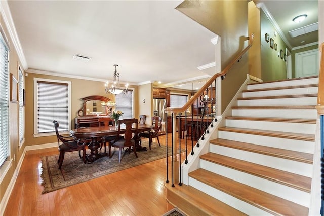 5878 General Diaz St, New Orleans, LA 70124 - dining space with stairway, ornamental molding, light wood-style floors, baseboards, and a chandelier