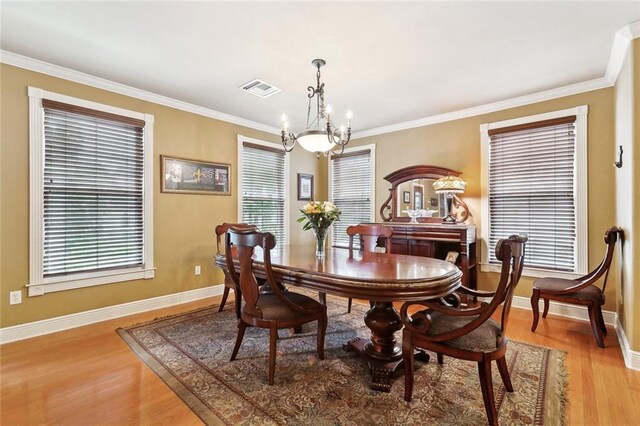 5878 General Diaz St, New Orleans, LA 70124 - dining space featuring a chandelier, light wood-type flooring, baseboards, and crown molding