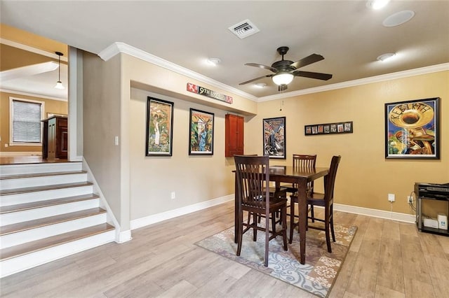 5878 General Diaz St, New Orleans, LA 70124 - dining area with ornamental molding, light wood finished floors, a ceiling fan, baseboards, and stairs