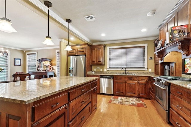 5878 General Diaz St, New Orleans, LA 70124 - kitchen with stainless steel appliances, light wood-type flooring, a sink, pendant lighting, and a center island