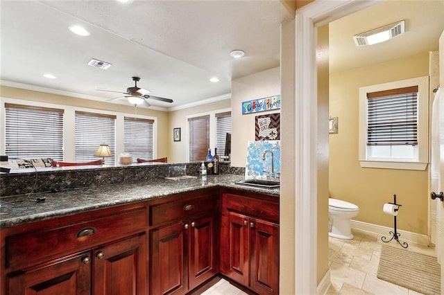 5878 General Diaz St, New Orleans, LA 70124 - bathroom with toilet, baseboards, vanity, stone tile flooring, and a ceiling fan