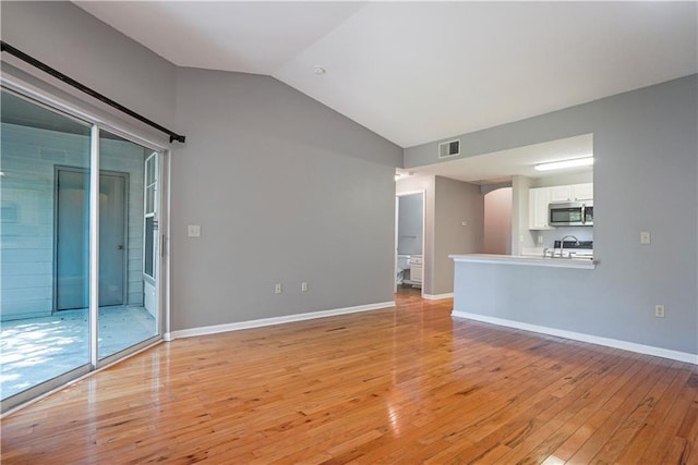 350 Emerald Forest Blvd Unit 9202, Covington, LA 70433 - unfurnished living room featuring lofted ceiling, light wood-type flooring, and baseboards