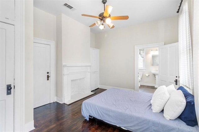 312 N Oak St, Hammond, LA 70401 - bedroom with dark wood-style floors, a fireplace, connected bathroom, a ceiling fan, and baseboards