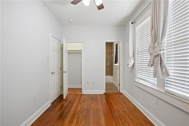 491113 Willow St, New Orleans, LA 70115 - unfurnished bedroom featuring hardwood / wood-style flooring, baseboards, a ceiling fan, ensuite bathroom, and a closet