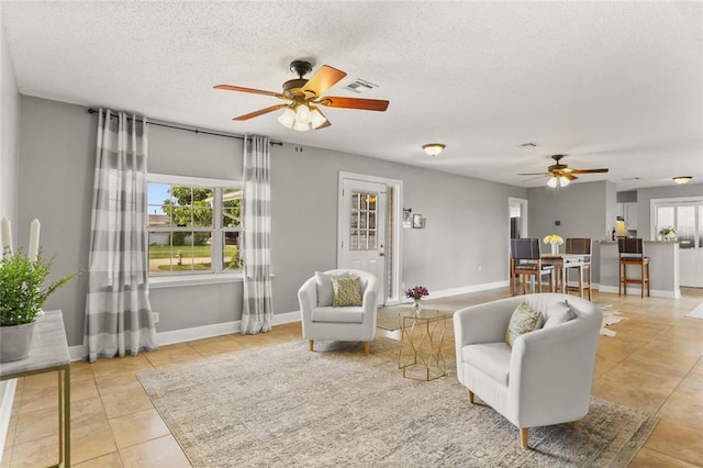 6020 Loraine St, Metairie, LA 70003 - tiled living area with a ceiling fan, a textured ceiling, and baseboards