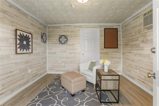 6020 Loraine St, Metairie, LA 70003 - sitting room featuring wooden walls, wood finished floors, baseboards, a wall mounted AC, and crown molding