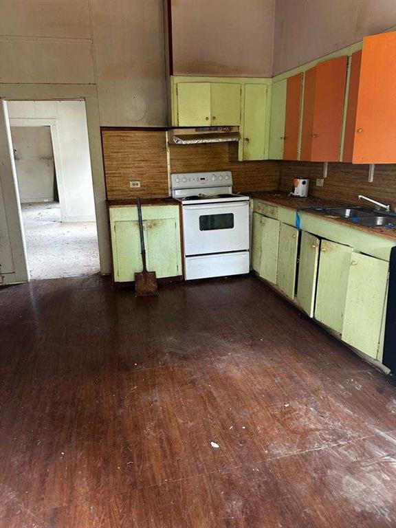 222 Tiger Ave, Independence, LA 70443 - kitchen featuring white electric range oven, under cabinet range hood, a sink, dark wood-style floors, and backsplash