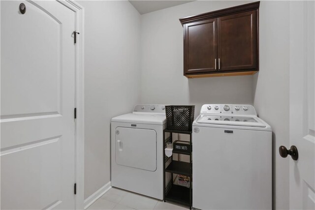 11537 Woodbluff Dr, Covington, LA 70433 - washroom featuring separate washer and dryer, cabinet space, light tile patterned floors, and baseboards