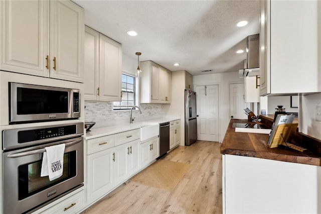 352 Moonraker Dr, Slidell, LA 70461 - kitchen featuring stainless steel appliances, a sink, backsplash, light wood-style floors, and recessed lighting