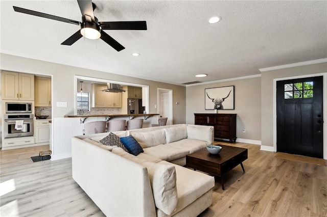 352 Moonraker Dr, Slidell, LA 70461 - living area with plenty of natural light, crown molding, light wood-style floors, a textured ceiling, and ceiling fan