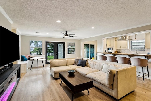 352 Moonraker Dr, Slidell, LA 70461 - living area featuring a textured ceiling, ornamental molding, healthy amount of natural light, light wood-style floors, and recessed lighting