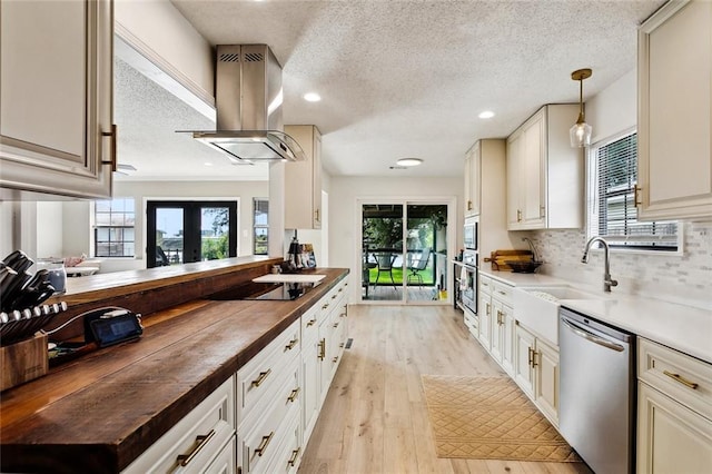 352 Moonraker Dr, Slidell, LA 70461 - kitchen with wood counters, appliances with stainless steel finishes, island range hood, a textured ceiling, and light wood-style flooring
