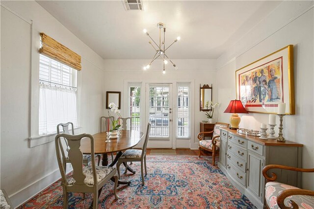 905-907 Pelican Ave, New Orleans, LA 70114 - dining room featuring plenty of natural light, a chandelier, baseboards, and wood finished floors