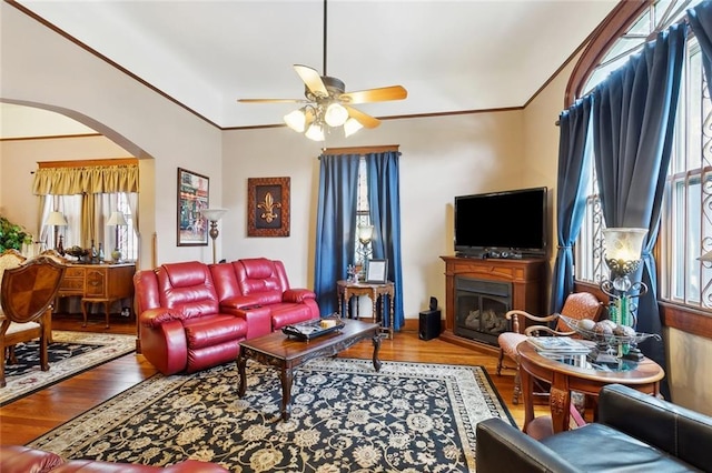 115 N Scott St, New Orleans, LA 70119 - living room with arched walkways, ceiling fan, wood finished floors, crown molding, and a fireplace