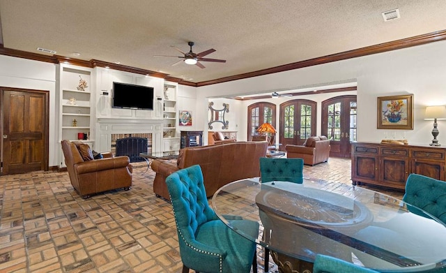 553 Beau Chene Dr, Mandeville, LA 70471 - dining room with ceiling fan, crown molding, a textured ceiling, a fireplace, and brick patterned flooring