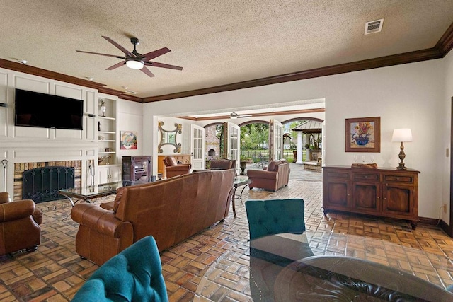 553 Beau Chene Dr, Mandeville, LA 70471 - living area with a ceiling fan, ornamental molding, brick flooring, a textured ceiling, and a fireplace