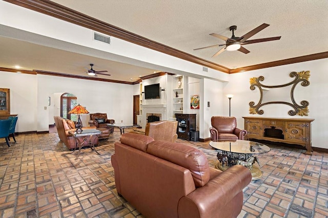 553 Beau Chene Dr, Mandeville, LA 70471 - living room featuring a fireplace, ceiling fan, brick flooring, crown molding, and a textured ceiling
