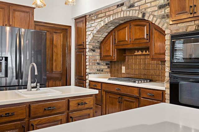 553 Beau Chene Dr, Mandeville, LA 70471 - kitchen with black appliances, brown cabinetry, light countertops, and tasteful backsplash