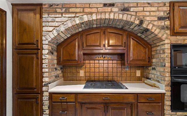 553 Beau Chene Dr, Mandeville, LA 70471 - kitchen with stainless steel gas cooktop, light countertops, brown cabinets, and decorative backsplash