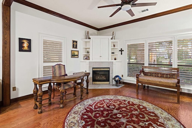 553 Beau Chene Dr, Mandeville, LA 70471 - office space with ceiling fan, wood finished floors, a tiled fireplace, and crown molding