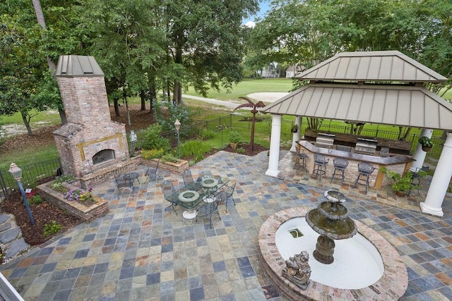 553 Beau Chene Dr, Mandeville, LA 70471 - fenced backyard featuring an outdoor brick fireplace, an outdoor kitchen, a patio area, a bar, and a gazebo