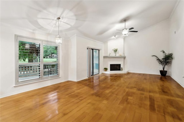 640 Tete Lours Dr Unit 28, Mandeville, LA 70471 - unfurnished living room with crown molding, wood finished floors, ceiling fan, a fireplace with raised hearth, and baseboards