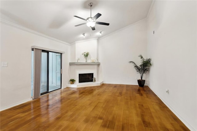 640 Tete Lours Dr Unit 28, Mandeville, LA 70471 - unfurnished living room featuring crown molding, a fireplace with raised hearth, ceiling fan, wood finished floors, and baseboards