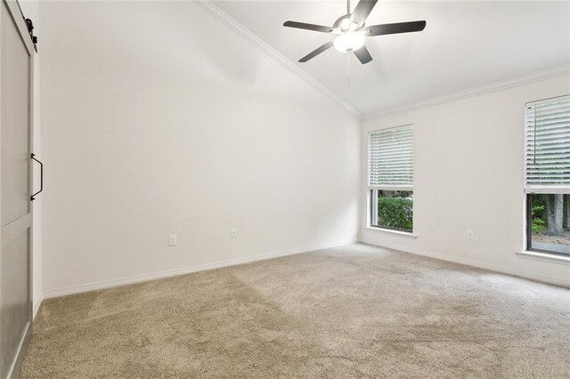 640 Tete Lours Dr Unit 28, Mandeville, LA 70471 - carpeted empty room with lofted ceiling, ornamental molding, baseboards, a ceiling fan, and a barn door