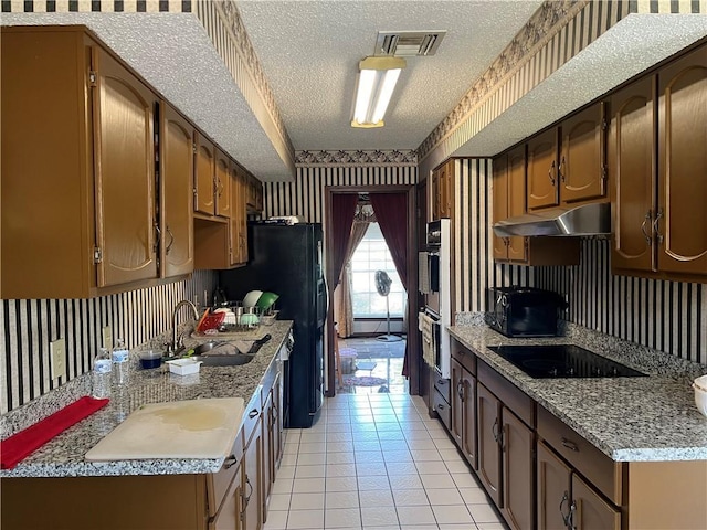 4300 Idaho Ave, Kenner, LA 70065 - kitchen with wallpapered walls, black appliances, a sink, under cabinet range hood, and a textured ceiling