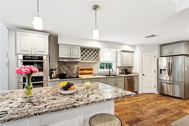 27044 Lucille Dr, Lacombe, LA 70445 - kitchen featuring appliances with stainless steel finishes, a sink, backsplash, and light stone counters