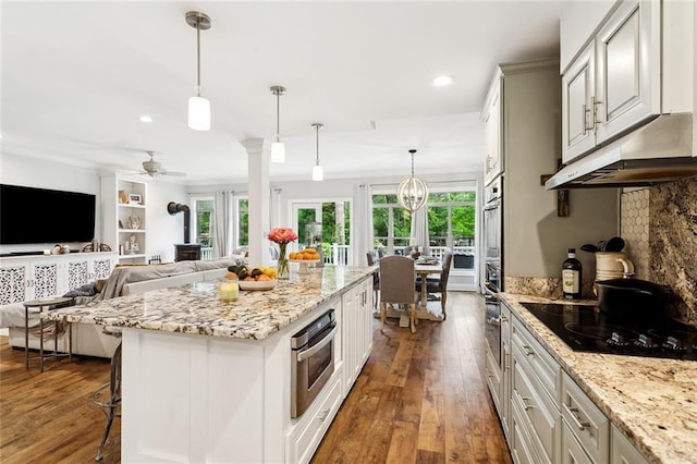 27044 Lucille Dr, Lacombe, LA 70445 - kitchen with oven, black electric stovetop, under cabinet range hood, dark wood finished floors, and crown molding