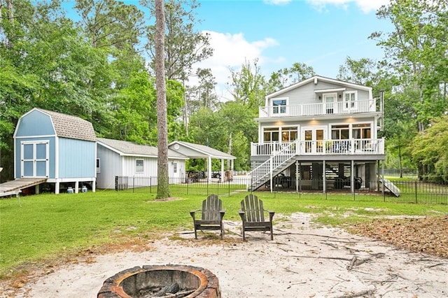 27044 Lucille Dr, Lacombe, LA 70445 - back of property featuring a fire pit, a balcony, stairs, a wooden deck, and view of scattered trees